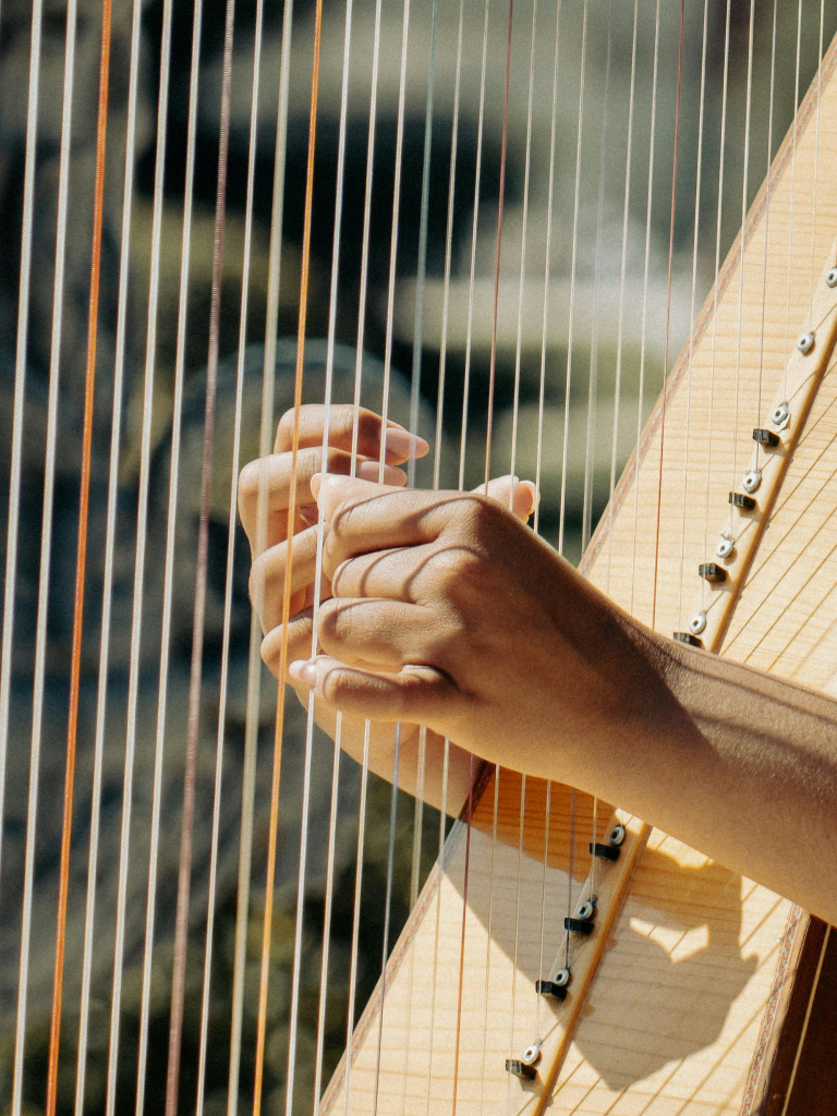 Hände, die Harfe spielen