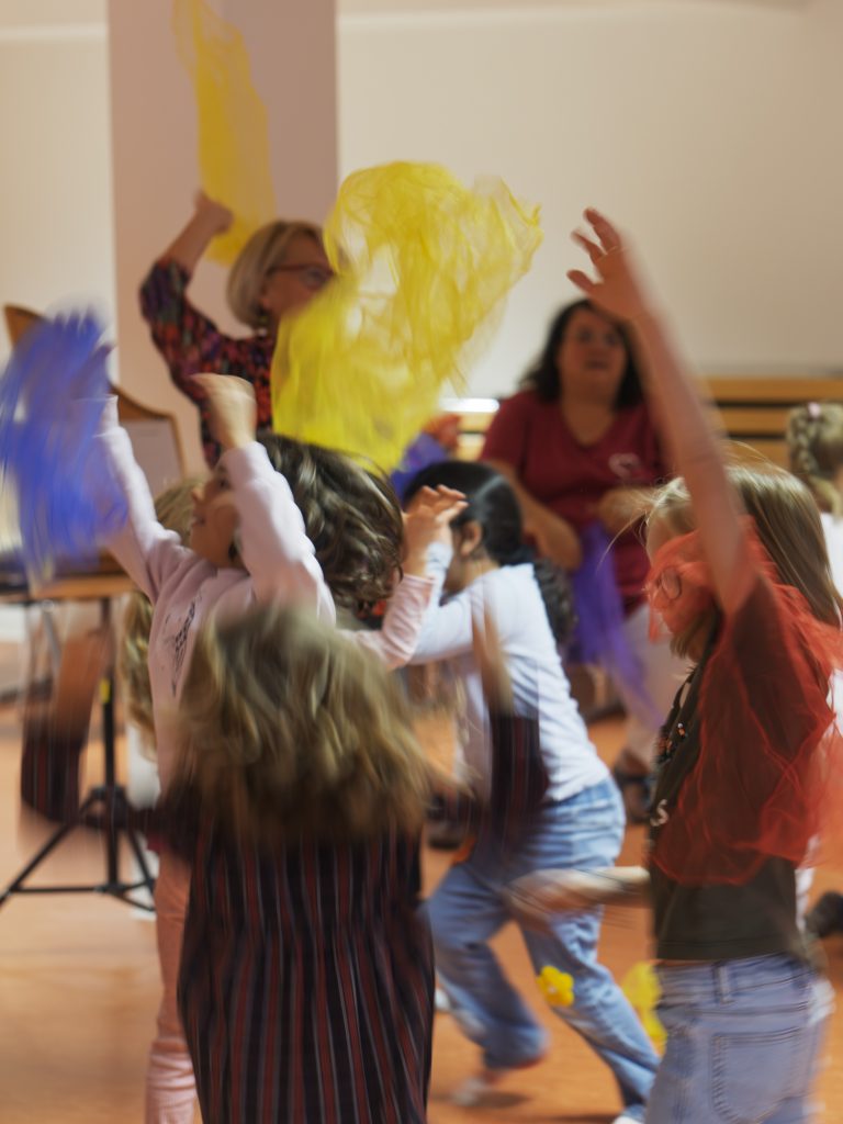 Kinder toben sich beim Tanz mit Tüchern aus. 