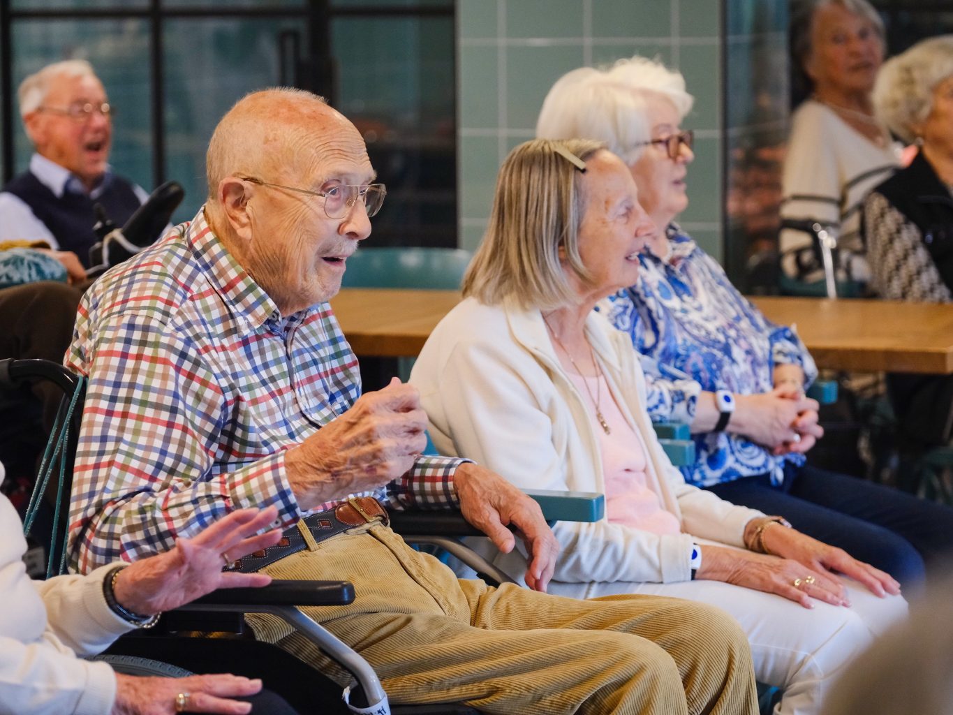 Begeistere Senior*innen singen und bewegen sich zur Musik. 