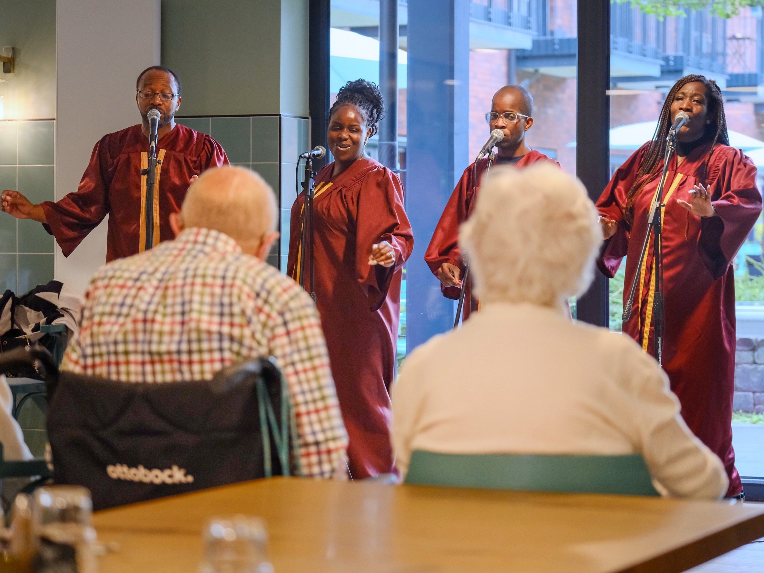 Der Gospelchor singt bewegt vor Senior*innen.