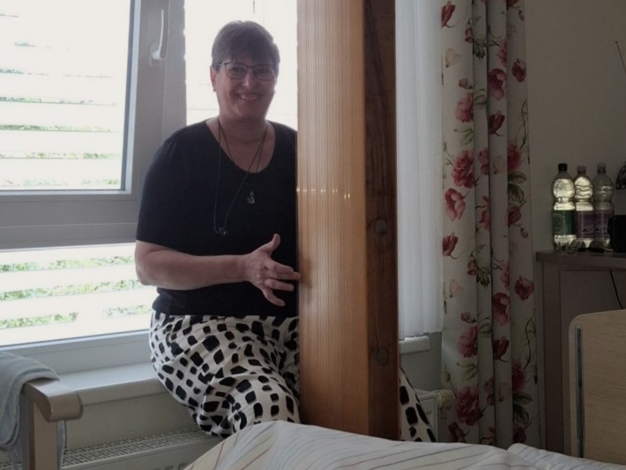 Harfenspielerin spielt am Bett einer älteren Person.