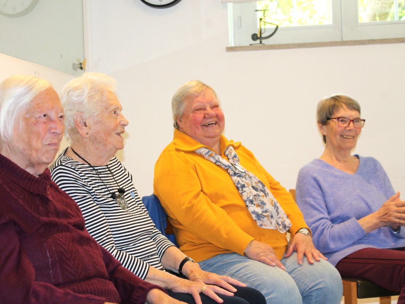 Serniorinnen sitzen im Kreis, sie lachen gemeinsam. 