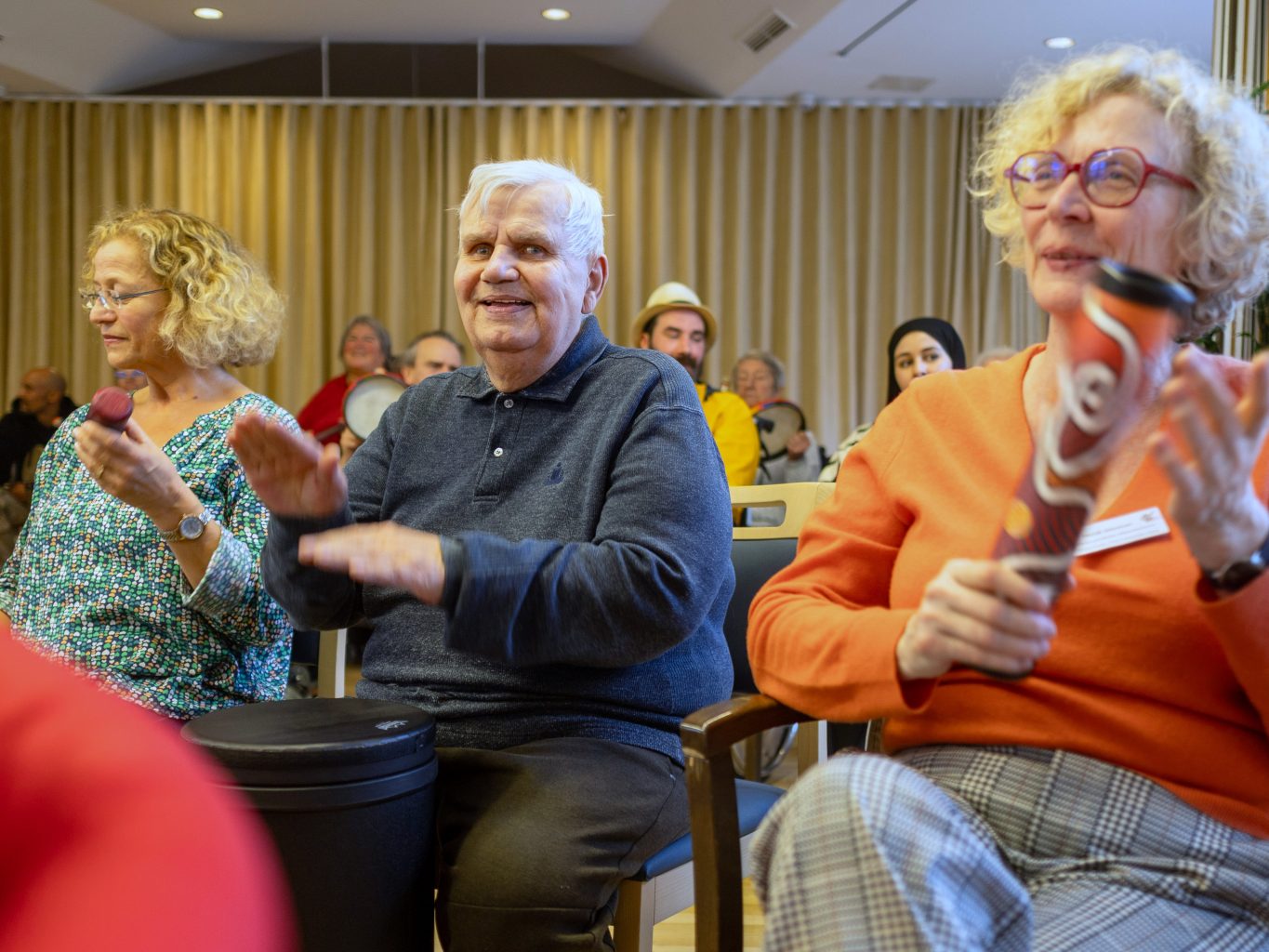 Eine Gruppe vpon Senior*innen trommelt gemeinsam. Sie haben sichtlich Freude. 