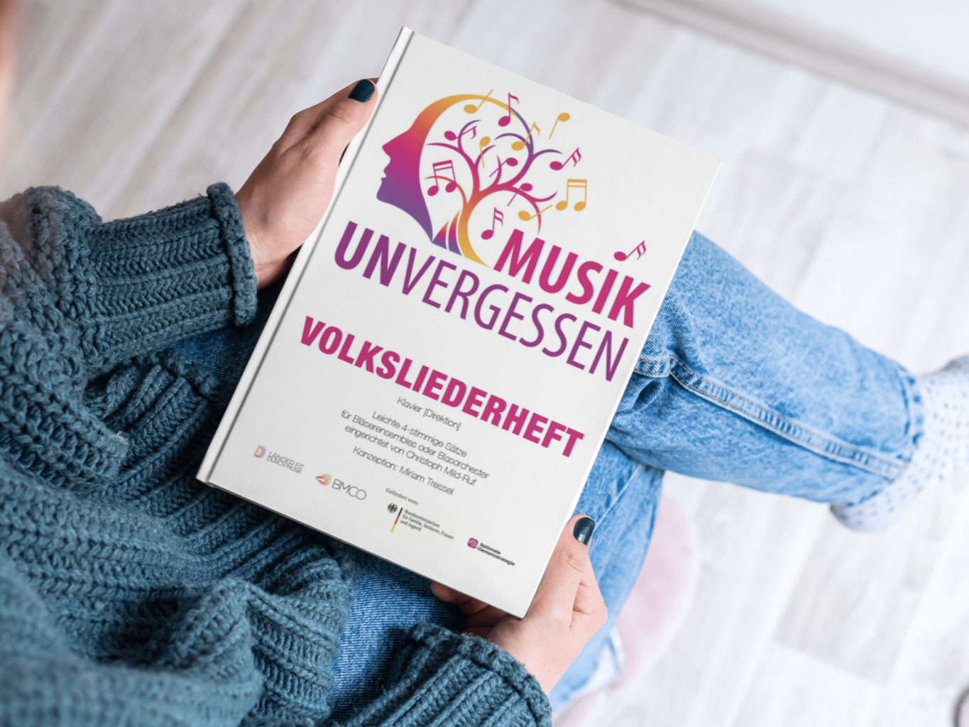 Foto einer Person, die das Volksliederheft auf dem Schoß hat. 